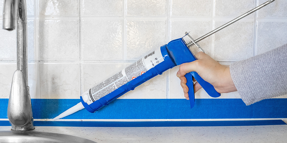 Gold Coast Caulking Services, Man caulking a Kitchen Back Splash